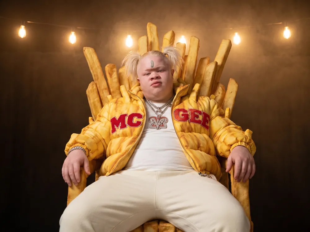 Fries McGee on a throne of giant fries under warm string lights